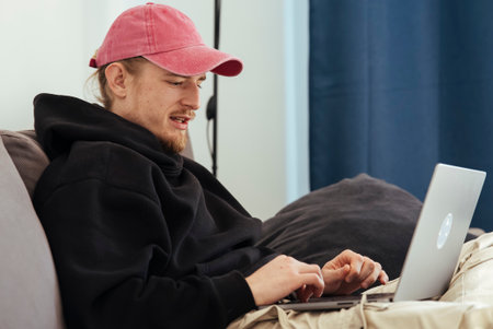 Person in casual attire celebrates success in cozy home settingの写真素材