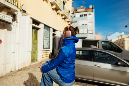 person wearing headphones looking up at city facadesの写真素材