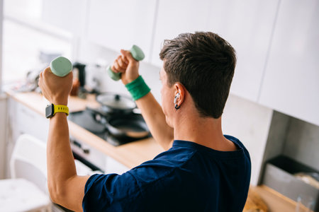 White man busy professional squeezing dumbbell workout during breakfastの写真素材