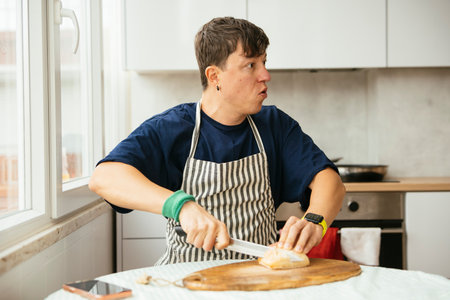 Man meticulously slicing bread in modern kitchen environment