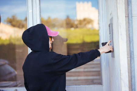 Person utilizing keypad to access structure during evening hours