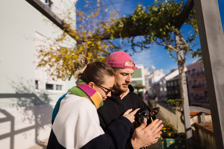 Couple collaborating over phone content amidst sunny outdoor setting