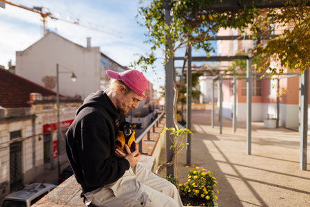 Teenager in pink hat looks at cityscape from balcony edgeの写真素材
