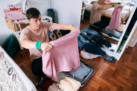 young asian man packing pink sweater as thoughtful gift