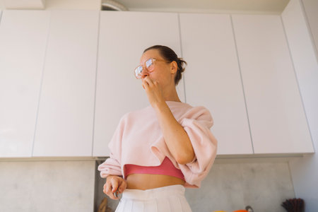 Relaxed woman in contemporary kitchen sampling homemade treatの写真素材