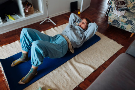 Lady performing indoor abdominal exercises wearing leisure wearの写真素材