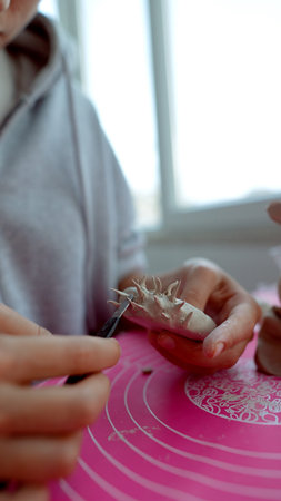 Steady hands assemble decorative clay features meticulously