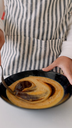 Closeup of hands blending caramel in cozy rustic kitchen setting