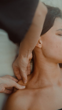 Professional therapist performing lymphatic drainage with calm demeanor