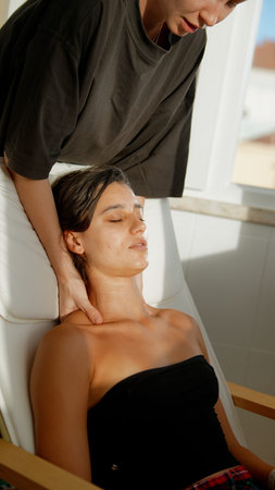 Person unwinds during soft neck massage inside sunny studio