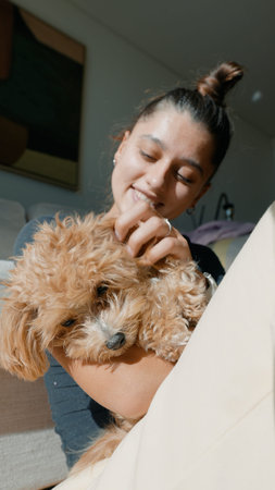 Woman cuddles puppy. Gentle woman comforts herself with puppy