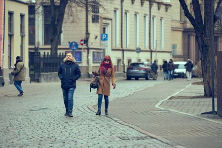 15-10-2019 Riga, Latvia. Autumn portrait of attractive happy couple walking at old town street.のeditorial素材