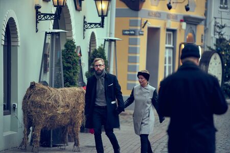 15-10-2019 Riga, Latvia. Autumn portrait of attractive happy couple walking at old town street.