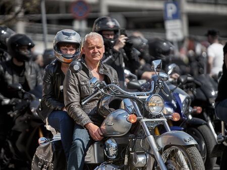 24-04-2019 Riga, Latvia Mature motorcyclist with passanger ready for ride.のeditorial素材