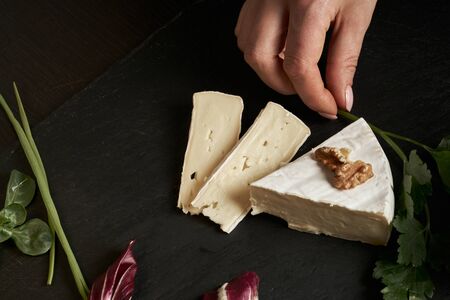 Cheese brie on dark stone background . Top view with space for text