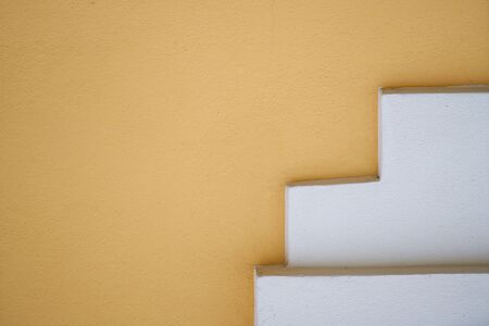 Background of old yellow painted wall and white stairs
