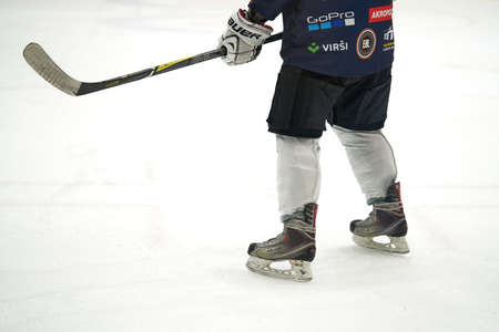 Tracking of ice hockey player in white uniform dribbling puck and doing reverse pass to teammates during practice in rinkのeditorial素材