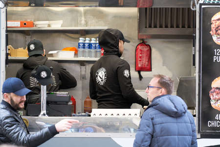 06-03-2020 Riga, Latvia street sale and people concept - happy young saleswoman at food truck...