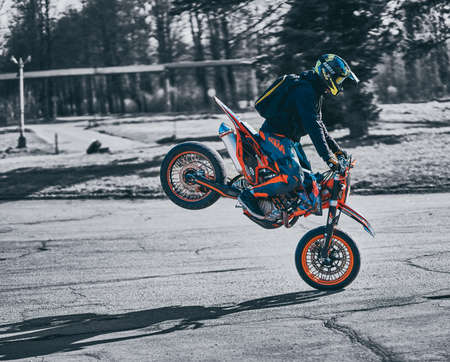 23-04-2020 Riga, Latvia Motorcyclist rides on front wheel on cross motorcycle.のeditorial素材