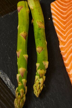 Salmon Fish Cooking Raw Fillet Pepper Salt Olive Oil Rosemary Lemon Green Asparagus Wooden Table Lifestyle Healthy Concept.の写真素材