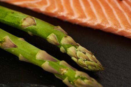 Salmon Fish Cooking Raw Fillet Pepper Salt Olive Oil Rosemary Lemon Green Asparagus Wooden Table Lifestyle Healthy Concept.の写真素材