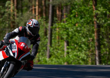 25-05-2020 Riga, Latvia. Motorcyclist goes on road, front view, closeup.のeditorial素材