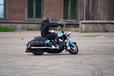 25-05-2020 Riga, Latvia. Motorcyclist goes on road, side view, closeup.
