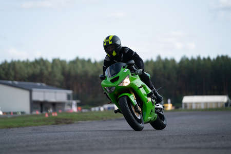 09/19/2020 Riga Latvia Handsome motorcyclist in black riding his super sport motorcycle