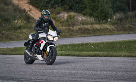 10-05-2020 Ropazi, Latvia Motorcyclist at sport bike rides by empty asphalt road. sport bike.