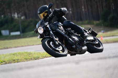 Motorcycle practice leaning into a fast corner on track.