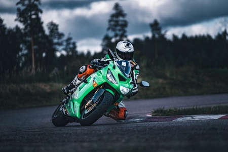 man riding motorcycle in asphalt road. Motorcyclist at black and white sport motorcycle.