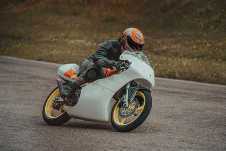man riding motorcycle in asphalt road. Motorcyclist at white sport motorcycle.のeditorial素材