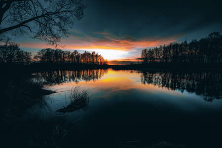 Reflections off a vivid Sunset sky over a Lake.の写真素材