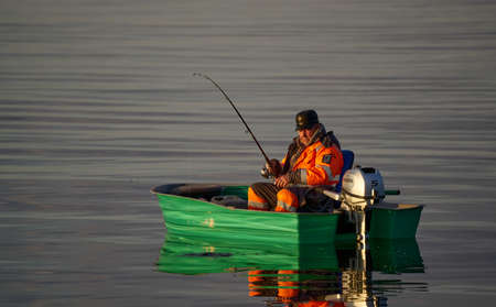 Fishing boat and fisherman in sea at dawn.のeditorial素材
