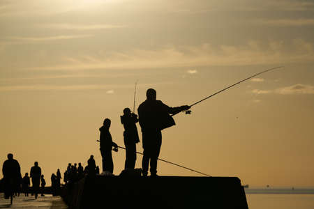 Fishing. spinning at sunset. Silhouette of a fishermanの写真素材