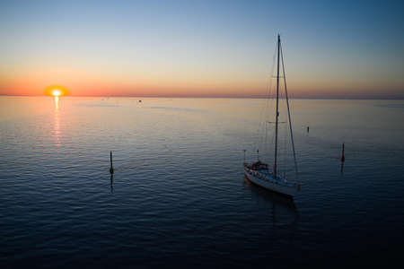 09-06-2021 Jurmala, Latvia Yacht sailing against sunset. Holiday lifestyle landscape. Yachting tourism - maritime evening walk. Romantic trip on luxury yacht during the sea sunsetのeditorial素材