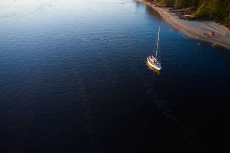 09-06-2021 Jurmala, Latvia Yacht sailing against sunset. Holiday lifestyle landscape. Yachting tourism - maritime evening walk. Romantic trip on luxury yacht during the sea sunsetのeditorial素材