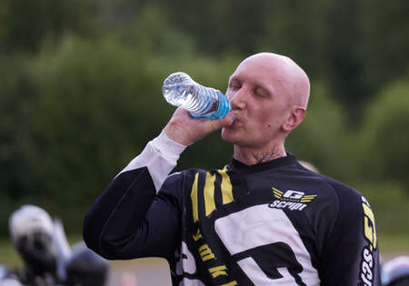01-07-2021 Riga, Latvia bald man drinking water.のeditorial素材