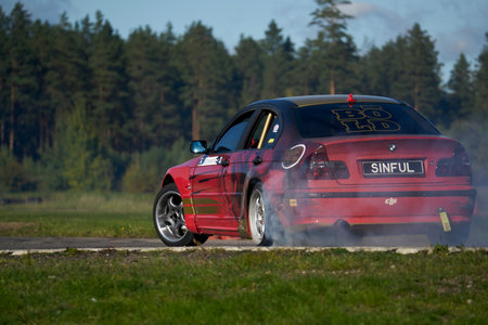 21-05-2021 Riga, Latvia Side view car drifting on track with grain, Sport car wheel drifting and...