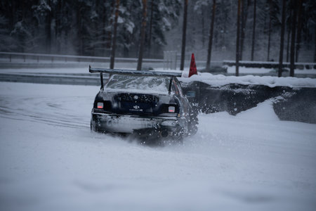 12-12-2022 Riga, Latvia a car driving through a snow covered road in the middle of winter with a snow bank on the back of it. .のeditorial素材