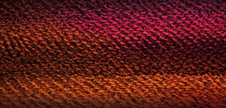 Red and orange knitted fabric background. Close-up of red and orange knitted fabric texture.の素材