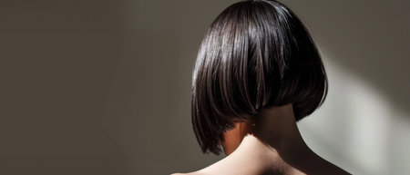 Back view of a young woman with short hairstyle in the studioの素材