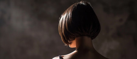 Portrait of a beautiful young girl with short hair on a dark backgroundの素材