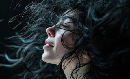 Closeup portrait of a beautiful woman with wind blowing her hair.の素材