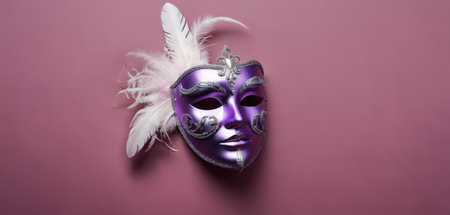 Purple Venetian mask with feathers on a pink background.の素材