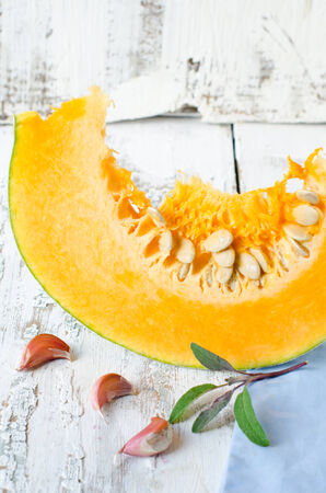 A piece of fresh pumpkin , sage and garlicの写真素材