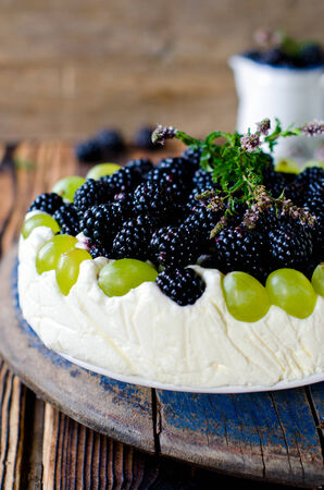 Cheesecake with blackberries and grapes on a wooden table oldの写真素材