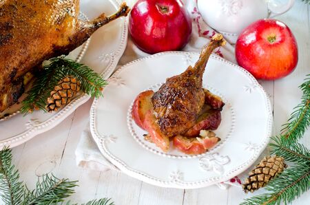 Christmas duck baked with apples on a white table with Christmas decorationsの写真素材
