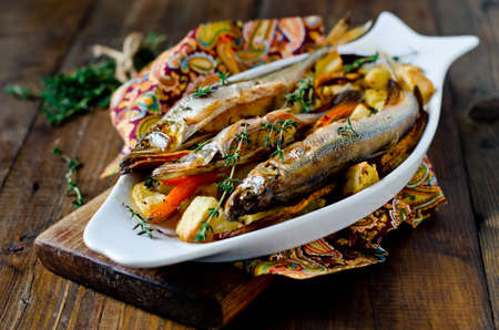 Fish (smelt) baked with potatoes and carrotsの写真素材