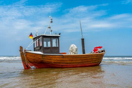 old wooden fishing boat at low tide on a beach